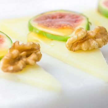 Slices of cured semi-hard Spanish goat cheese with walnuts, ripe